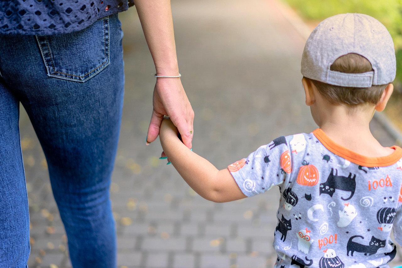 子こども手をつなぐ母親の後ろ姿。夜勤と子育ての両膣に悩んだ看護師のイメージ